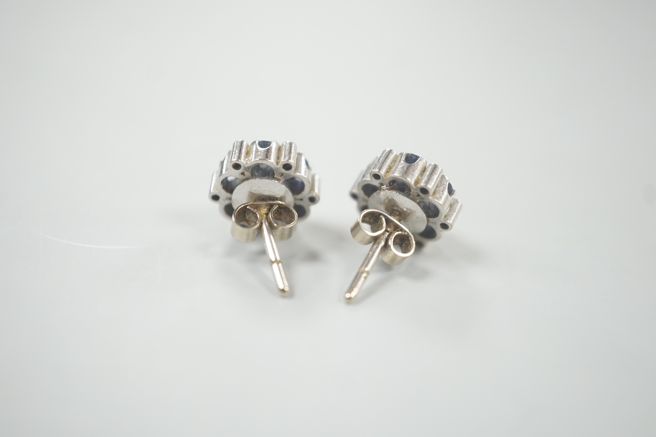 A pair of white metal, sapphire and diamond cluster set flower head ear studs, 10mm, gross weight 4.6 grams.